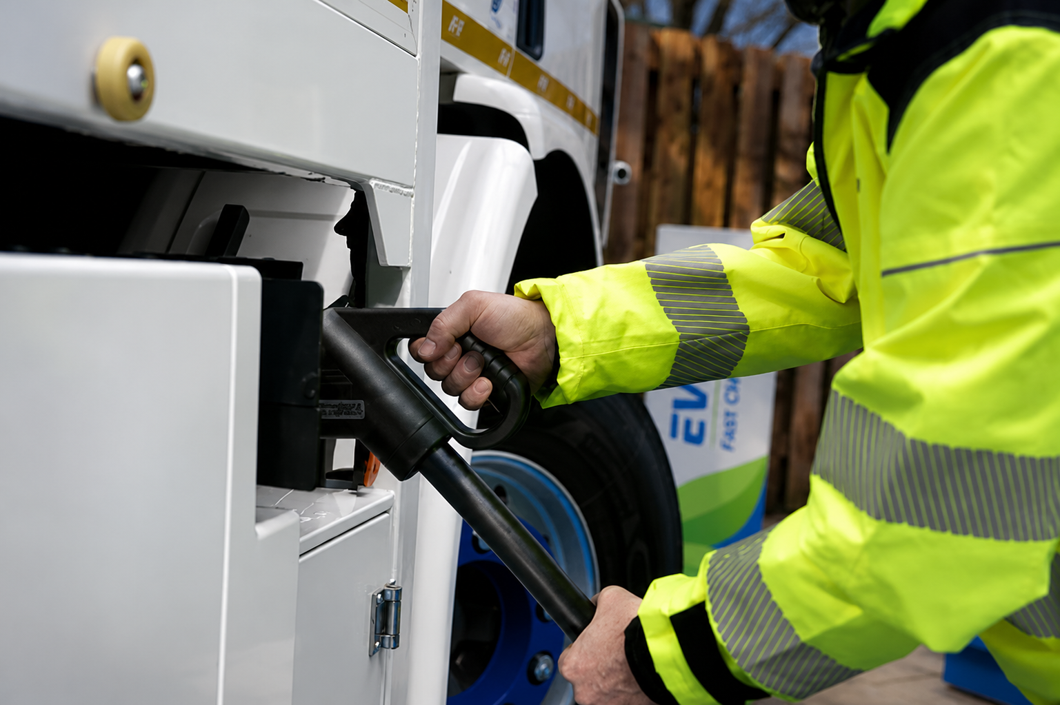 Close-up of a BT-HS operative plugging the Electric IPV into an EV fast-charger