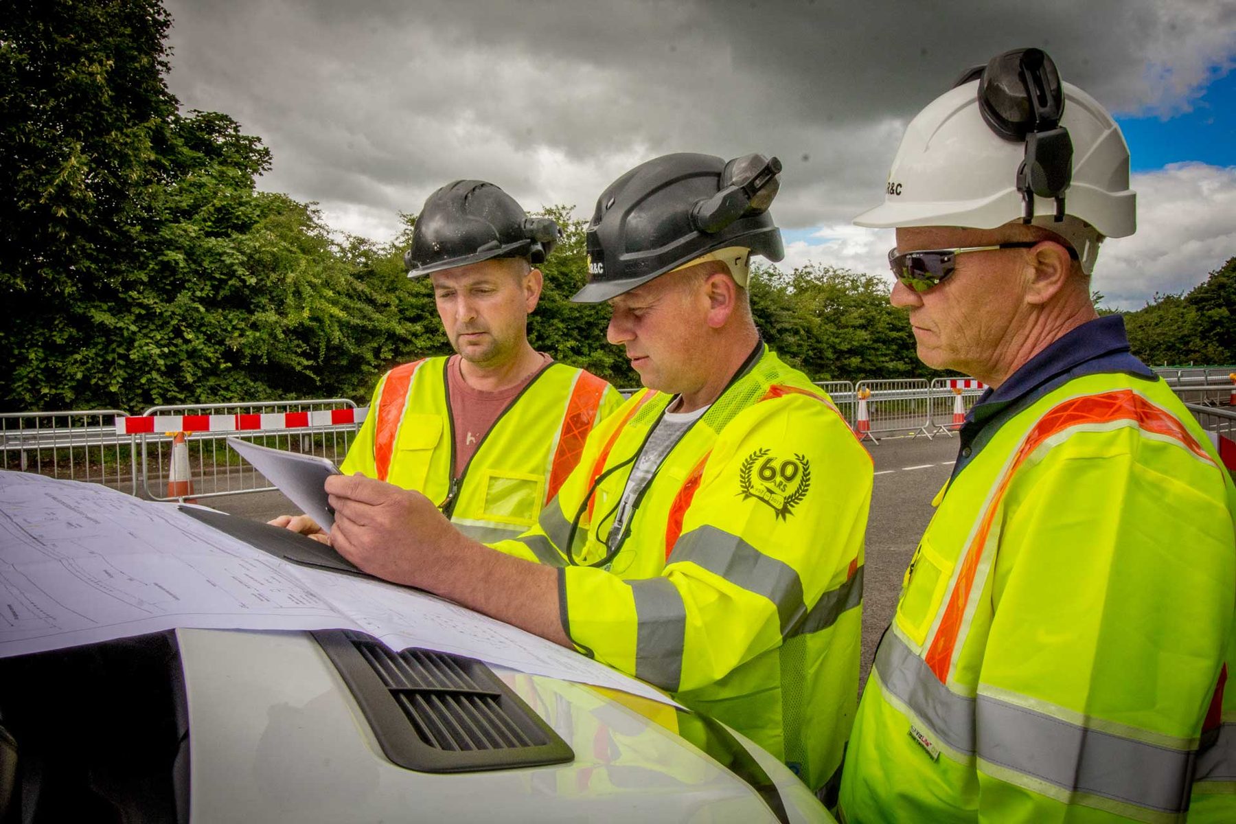 R&C Williams site team reviewing project plans on site, showing 60-years branding