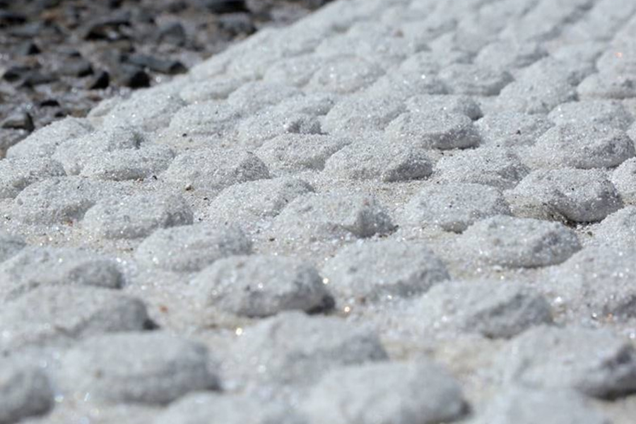 Macro close-up of the high-friction glass beads that give WJ road markings their retroreflective performance